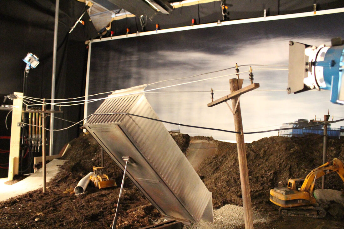 A hand-built 1:6 miniature construction site with powerline poles, dump truck and figures
