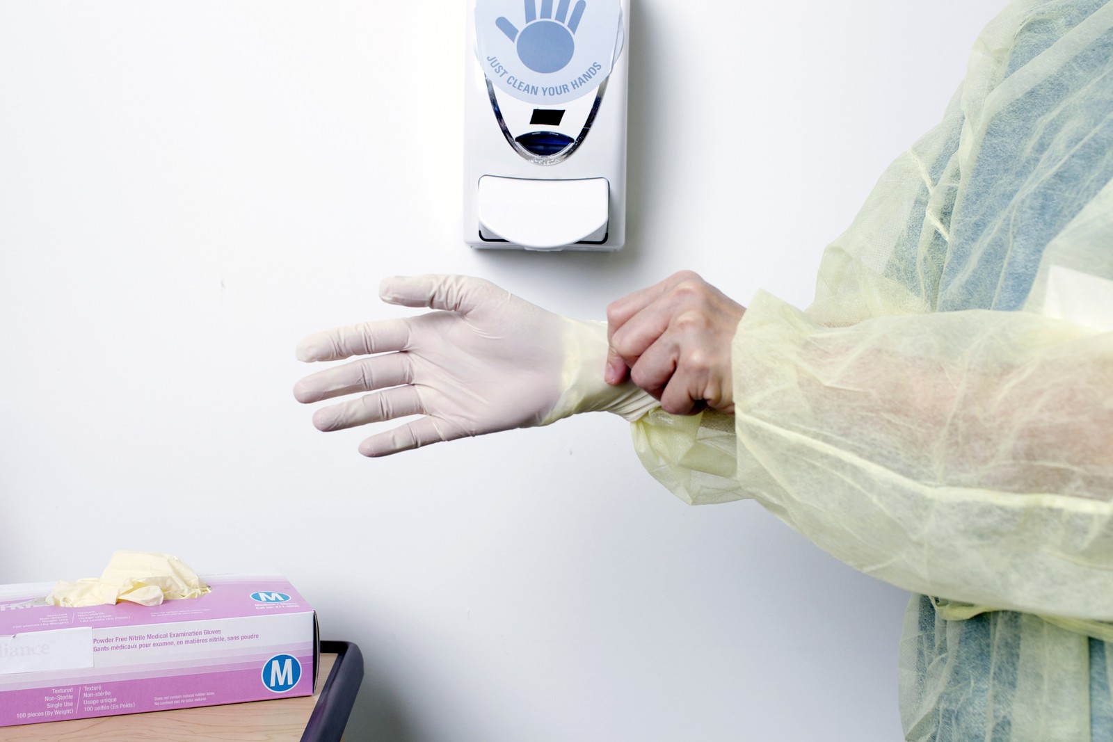 Donning gloves: pulling a glove on over the gown cuff