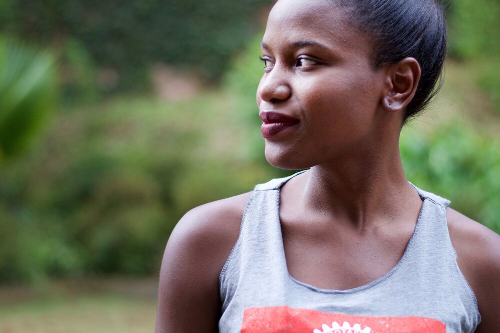 Patience Asiimwe in profile, wearing a Rotary International top, from the documentary Two Drops of Patience