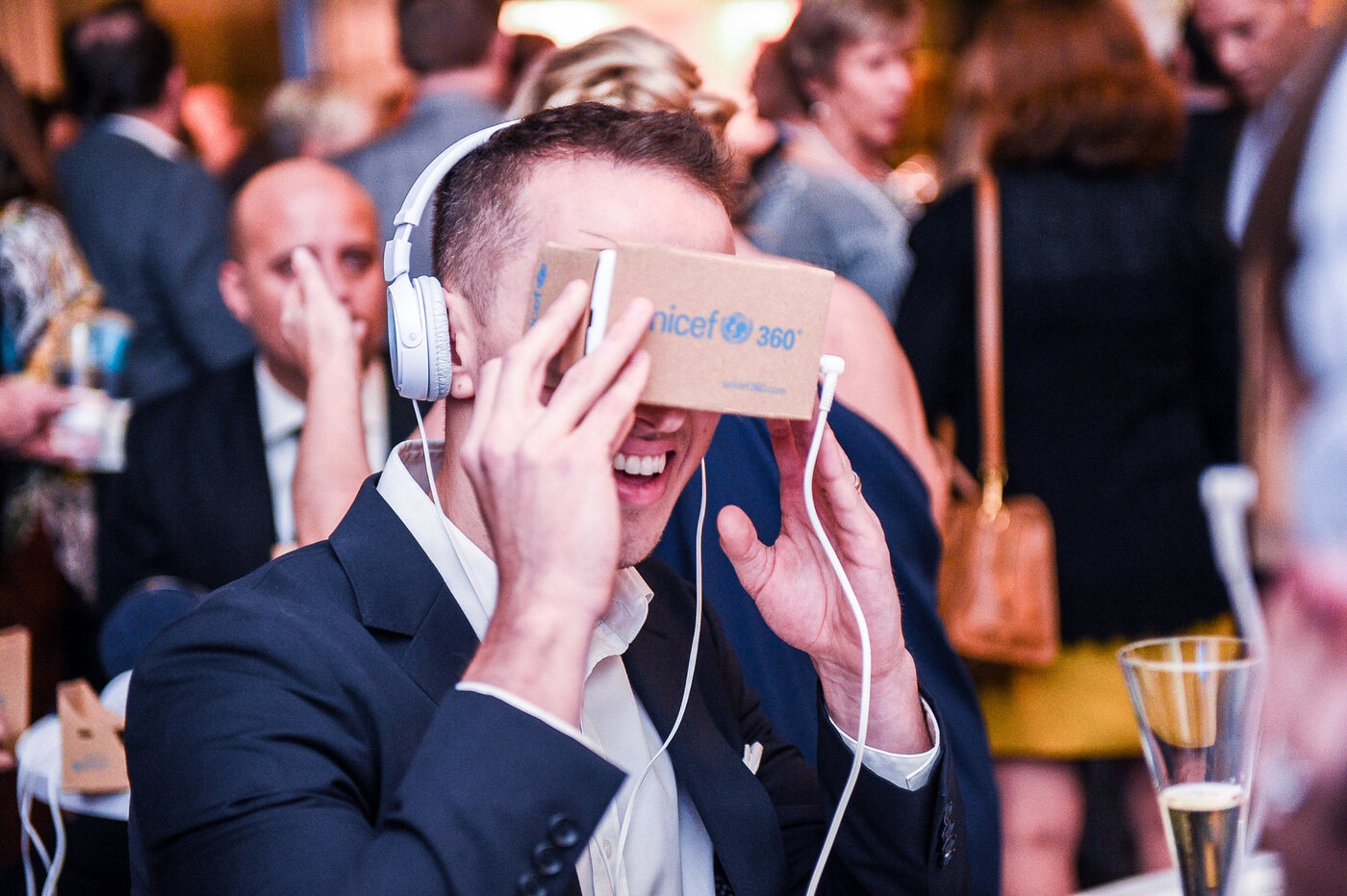 A guest reacting with delight during a UNICEF360 experience at a fundraising event